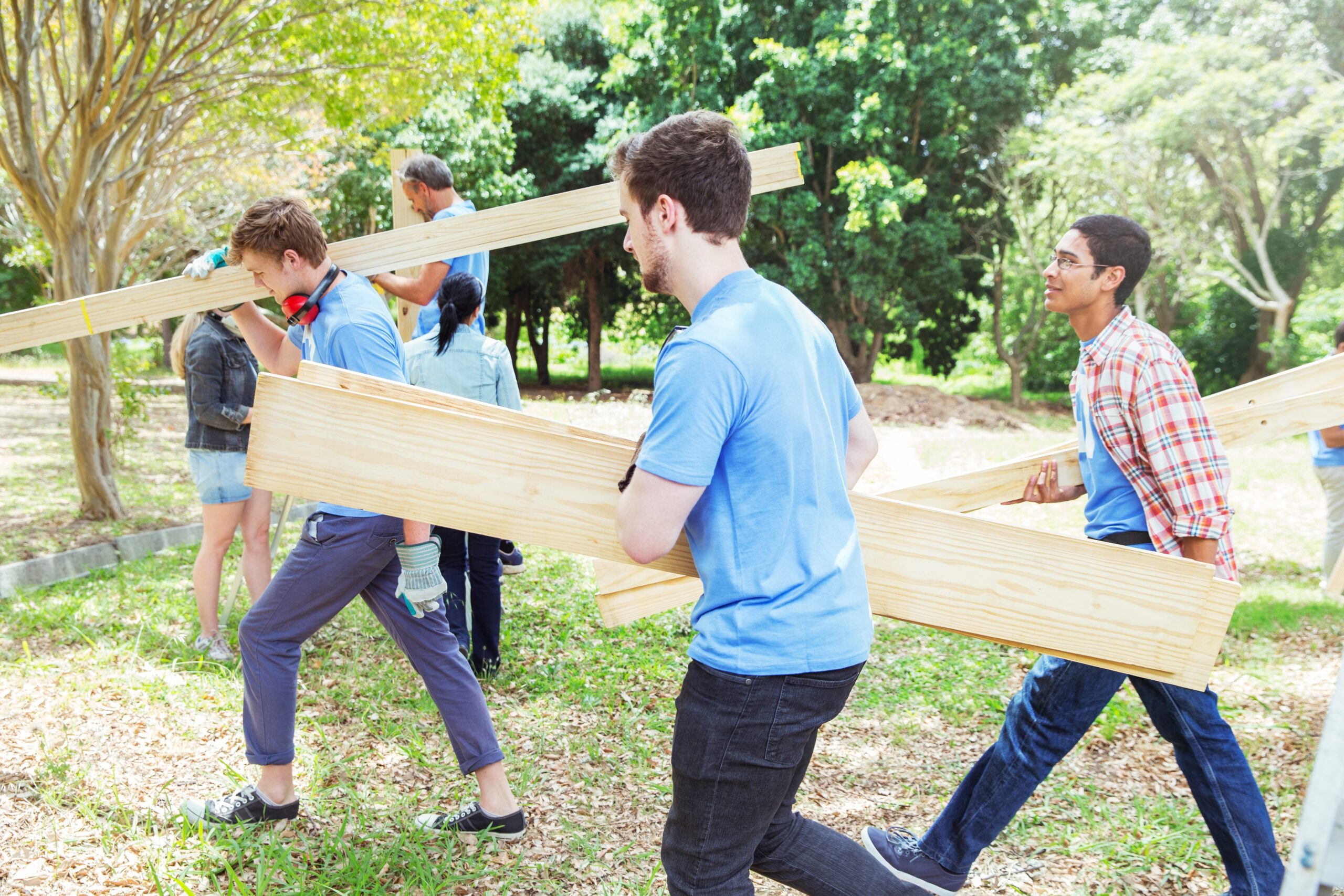 Humanitarian volunteers carrying wood planks